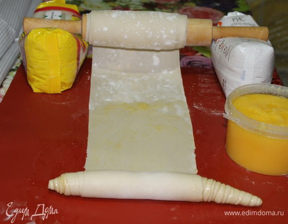 Далее раскатываем тесто в ленту, смазываем ее тонким слоем топленого масла. В идеале используется свиной жир (смалец), но за неимением такового, масло — отличная альтернатива.  Начинаете сворачивать тесто в плотный рулон, слегка растягивая его края  в стороны. 