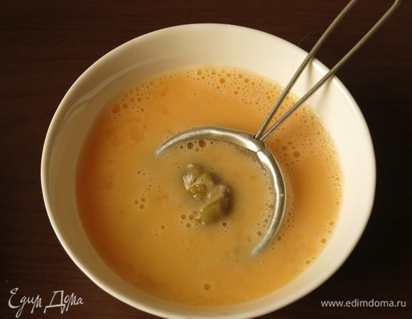 Опускаем оливки в кляр, удобно использовать сито.