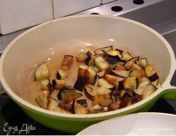 Разогреть в сковороде 2 ст. ложки оливкового масла и обжарить нарезанный баклажан до золотистого цвета, затем добавить чили, черный перец и соль, все перемешать.