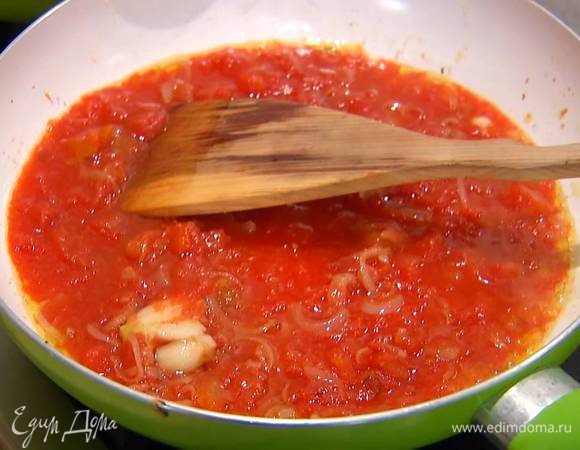 Приготовить соус: разогреть в сковороде оставшееся оливковое масло и обжарить лук и чеснок, затем добавить помидоры в собственном соку, чили, черный перец и соль, все перемешать и прогреть.