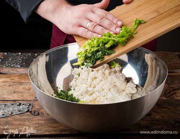 Петрушку и зеленый лук мелко порубить. Нарубленную зелень и листья тимьяна добавить к творогу. 