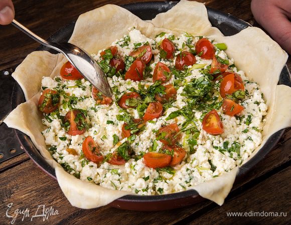 Выложить в центр формы творожную начинку, а сверху — помидоры с базиликом.