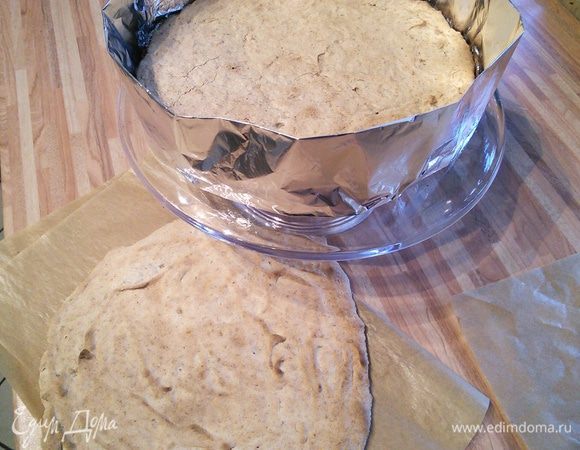 Выкладываем один из коржей на блюдо. Вокруг устанавливаем круг от разъемной формы (у меня конструкция из фольги).