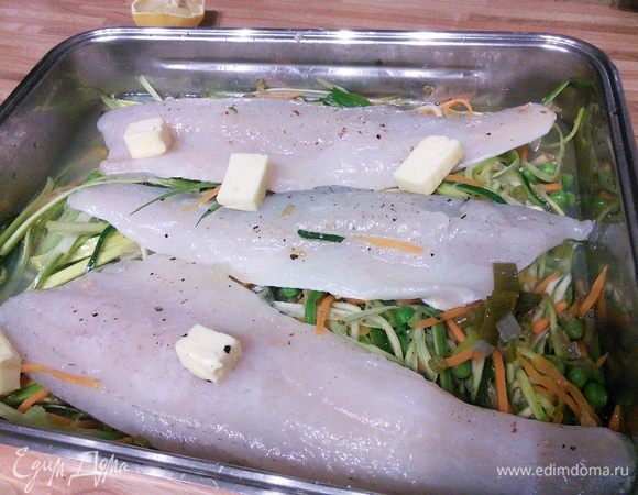 На овощи выложить рыбу, влить вино и рыбный бульон, хлопьями разложить оставшееся масло. Запекать в заранее разогретой до 180°С 15 минут. Через это время нужно вынуть форму из духовки и слить соус в отдельную емкость. Нам понадобится 250 мл соуса, который нужно перелить в сотейник (я взяла сковородку, т. к.  площадь поверхности больше и соус будет выпариваться быстрее). Рыбу вернуть обратно в духовку, но выключить огонь. В целом рыба не должна провести в духовке дольше 20 — 25 минут.