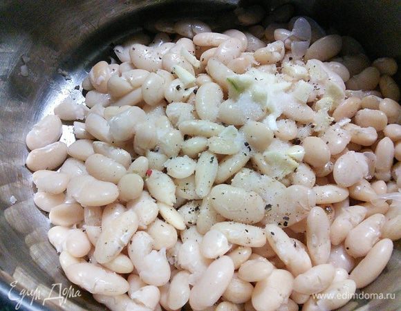Для начала отварить фасоль. Замачивалась на ночь в холодной воде, с утра промываем и варим без соли до готовности (2 часа подготовительного времени я указала именно на варку фасоли). С готовой фасоли слить воду, посолить и поперчить. Добавить измельченный чеснок.