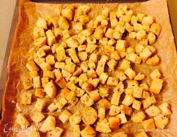 Духовку нагреть до 200°С. Кубики багета хорошо перемешать с чесночным маслом и отправить в духовку на 10 — 12 минут.