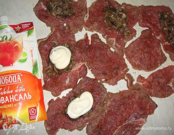 Кусочки мяса посолить и поперчить по вкусу. Выложить начинку на середину каждого кусочка, сверху выдавить майонез Провансаль ТМ «Слобода».