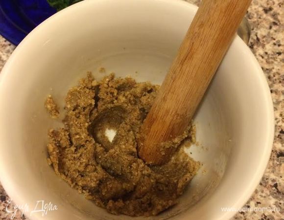 Орехи пропустить через мясорубку. Переложить в ступку, добавить чеснок (пропущенный через пресс), специи, соль, уксус, перец и все хорошо перетереть.