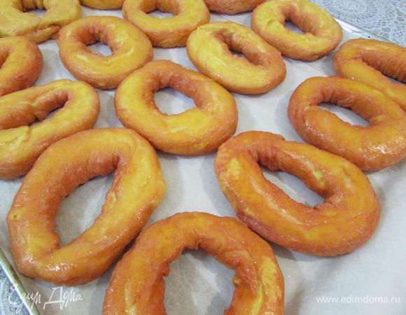 Противень застелить пекарской бумагой, промазать лист сливочным маслом. Выложить бублики на подготовленный противень, подсушенной стороной вниз.