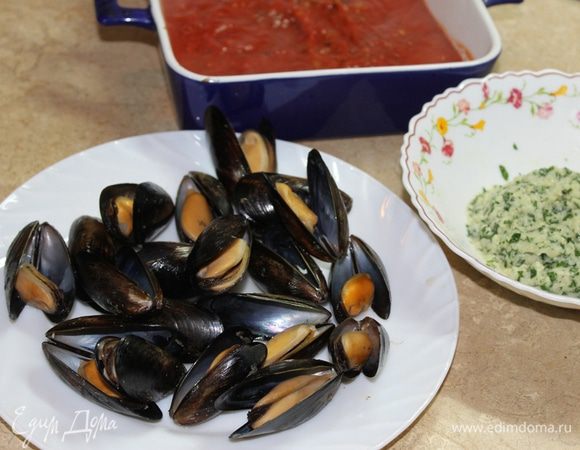 В форму для запекания налейте томатный соус. Мидии нафаршируйте подготовленной начинкой, закройте ракушку и закрепите ниткой, сделав несколько оборотов вокруг раковины.