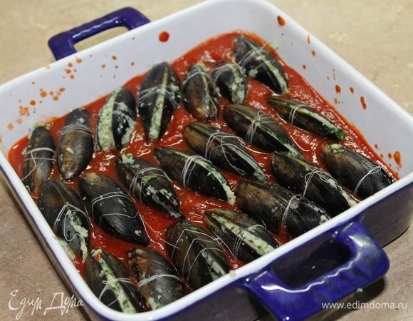 Кладите мидии в соус перпендикулярно.