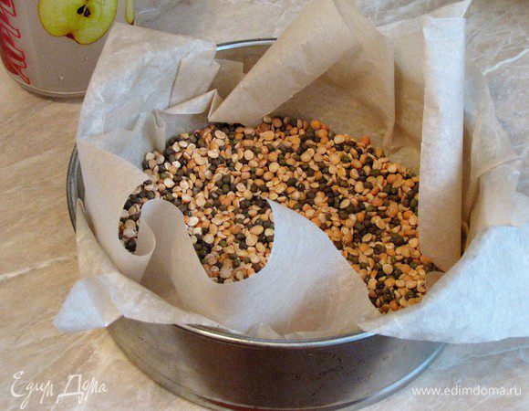 Разогреть духовку до 180°С. Вынуть тесто из холодильника, накрыть бумагой для выпечки, насыпать фасоль или горох, выпекать 15 минут. Затем убрать бумагу с фасолью и выпекать еще 10 минут.