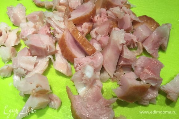 У копченого куриного окорочка удалите кожу, отделите мясо от костей и нарежьте небольшими кусочками.