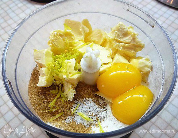 В чаше комбайна смешиваем муку, охлажденные желтки и сливочное масло, сахар, щепотку соли и цедру лимона.
