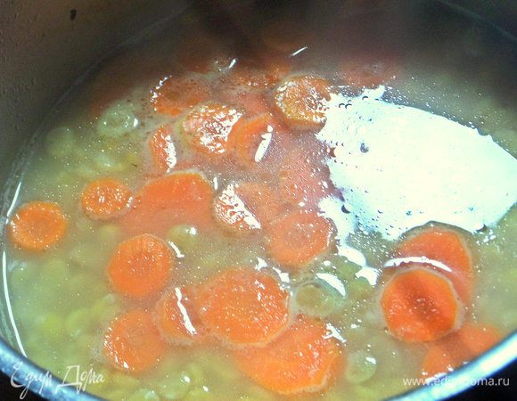 Всыпать замоченный горох. Позже добавить морковь, нарезанную любым способом.