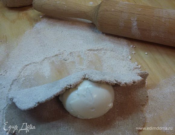 Разделить тесто на 6 частей. Каждую часть раскатайте в тонкую лепешку. На середину лепешки положите яйцо и заверните в тесто.