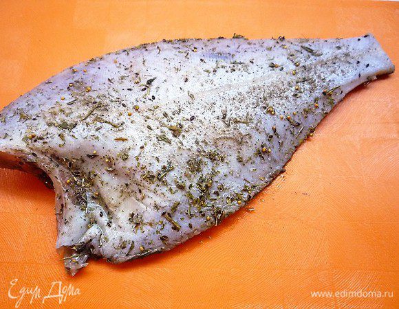 Камбалу промываем под холодной водой, срезаем голову, плавники и хвост. С обеих сторон натираем солью, перцем и майораном.