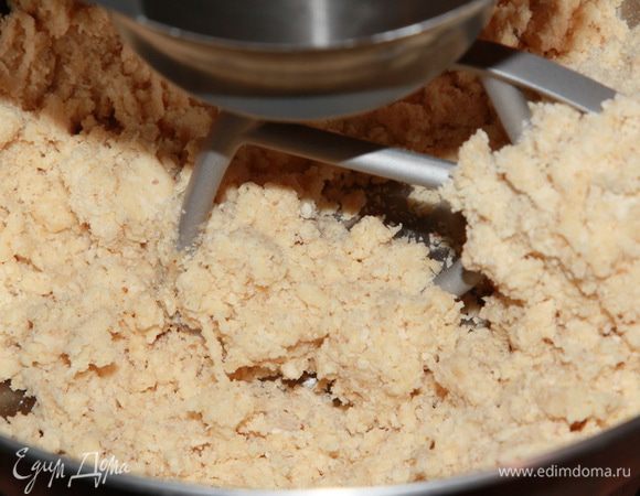 Затем добавляем 36 граммов яйца. Да, вот такой вес. Для этого вилочкой легонько взбиваем яйцо и отвешиваем от общего количества 36 граммов. Я не знаю, может 40 граммов тоже будет хорошо, или 35, но я не пробовала. На средней скорости продолжаем смешивать ингредиенты. Они начнут собираться в комок. Сначала так.