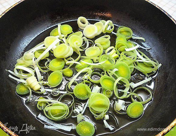 Белую часть стебля лука-порея нарезаем тонкими кольцами и слегка обжариваем на оливковом масле с обеих сторон.