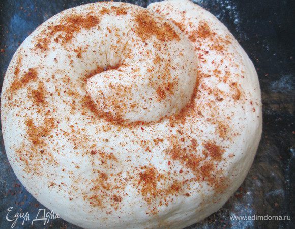 Сворачиваем в рулет и затем в «улитку». Укладываем ее на силиконовый коврик, посыпаем паприкой, чуть прижимаем руками и оставляем на расстойке на 1,5 часа.