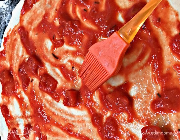 Тесто выкладываем на противень, предварительно посыпанный мукой. Выкладываем соус.