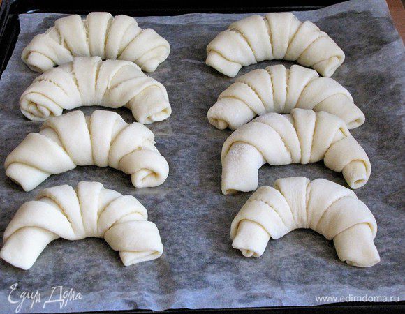 Сформировать рогалики и выложить на противень, застеленный пекарской бумагой. Бумагу я смазала маслом, на всякий случай. Дать рогаликам подойти.