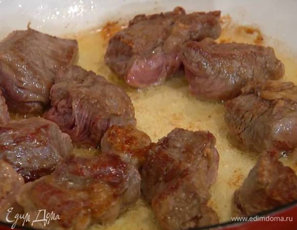 Разогреть в тяжелой, глубокой сковороде 2 ст. ложки оливкового масла и обжаривать мясо со всех сторон до появления золотистой корочки, затем переложить на тарелку.