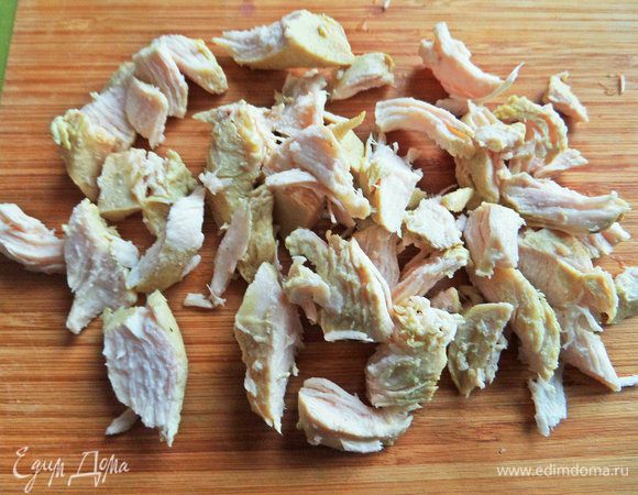 Курицу (половину грудки) достать из бульона, нарезать.