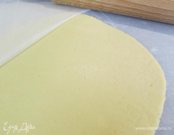 Тесто раскатать между двумя листами пергамента. Формочкой вырезать печенье. Можно просто нарезать тесто на ромбики.