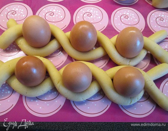 Соединяем по 2 жгутика и укладываем в них по 3 яйца, переплетая между собой. Концы оставляем свободными. Есть маленький семейный секрет: яйца вначале лучшее отварить, чтобы они не растрескались. Я использовала все-таки сырые, но мне повезло и они остались целыми.