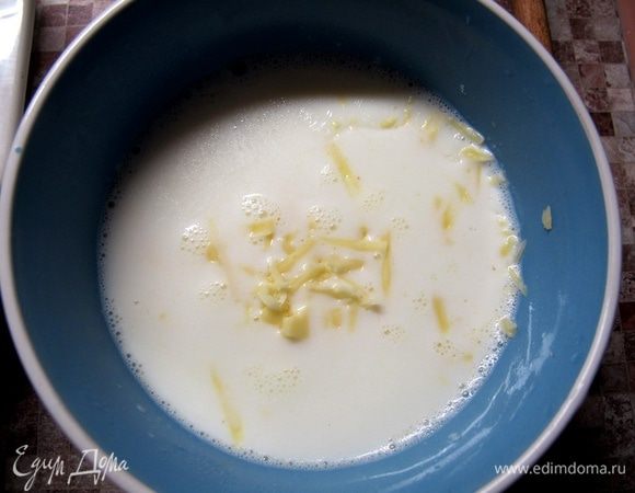 Молоко нагреть примерно до 60°С. Сыр натереть. Половину сыра положить в молоко, туда же добавить муку и хорошо размешать.