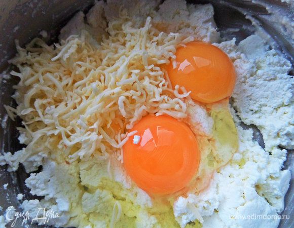 Для верхнего слоя смешать творог, яйца и сыр, оставив немного сыра для верха.