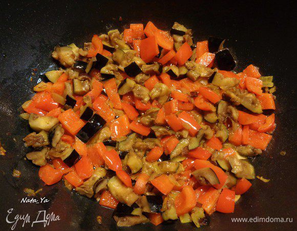 Добавить перец к луку и чесноку. Баклажан отжать от лишней жидкости и тоже добавить к другим овощам. Потушить все несколько минут до легкого золотистого цвета.
