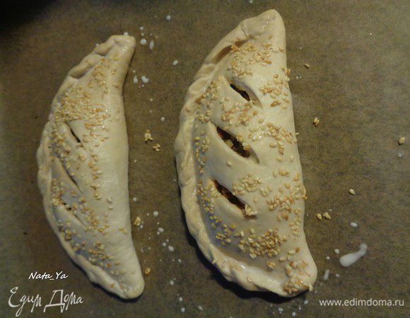 Повторить так с оставшимся тестом. На каждой кальцоне сделать надрезы для выхода пара и для того, чтоб начинка не вытекла. Смазать молоком и присыпать обжаренным на сухой сковороде кунжутом.