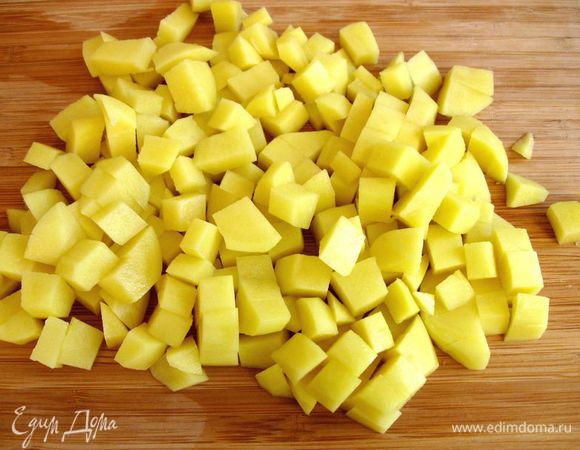 Нарезать кубиками картофель. Такая нарезка позволяет ему равномерно приготовиться. Поместить его в сотейник, залить кипятком, чтобы тот только его покрывал. Добавить щепотку соли, довести до кипения, варить на медленном огне в течение 10 минут.