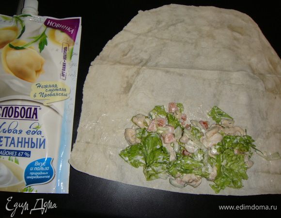 Листы лаваша разрезать пополам. Выложить часть начинки на один край, подвернуть лаваш с двух сторон и свернуть рулетом.