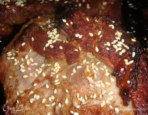 Через 30 минут снять фольгу, полить мясо соком из формы и посыпать кунжутом. Запекать еще 30 минут, убавив температуру до 190°С.
