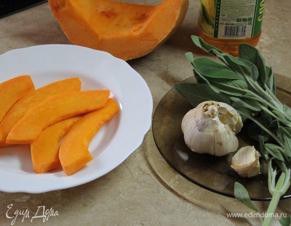 Ореховую тыкву нарежьте тонкими ломтиками, очистите зубок чеснока, оборвите листики шалфея.