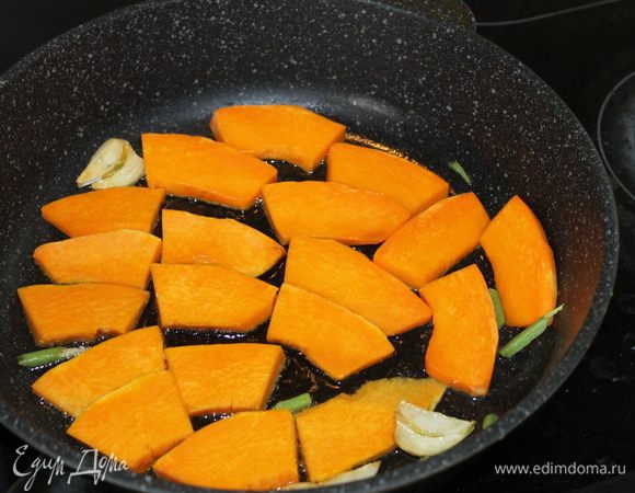 В ароматное масло выложите нарезанную тыкву и обжарьте ее с двух сторон, сдобрив солью и перцем.