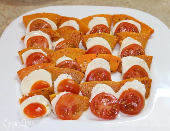 Собираем салат. На блюде выложите чередуя теплую тыкву, на тыкву моцареллу, ломтики помидоров, сдобрите крупной морской солью и молотым перцем.