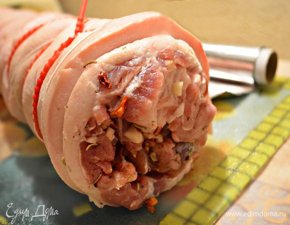 Оберните подготовленную поркетту в пекарскую бумагу, чтобы при запекании кожа не пригорела и не прилипала к фольге. Затем уже в бумаге заверните поркетту в двойной слой фольги и уберите на сутки в холодильник. Мясо за это время должно хорошо промариноваться в чесноке и специях.