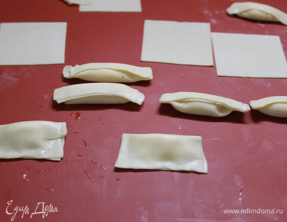 Сложите квадратик пополам и аккуратно придавите края между собой. У вас получился прямоугольник 7х3, 5 см. Сложите еще раз уголки, паста стала похожа на сигару размером 7х1,75 см. Готовые равиоли необходимо подсушить, для этого припудрите мукой поверхность стола, разложите пасту и оставьте ее на 30 минут подсохнуть.