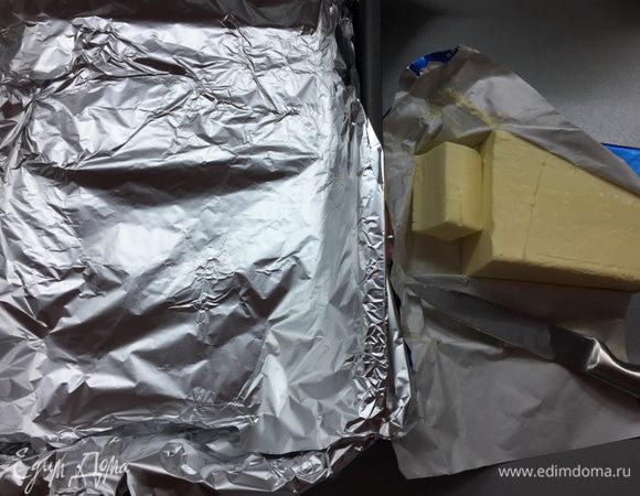 Разогреваем духовку до 210°С. Готовим форму для запекания: ее удобно выстелить фольгой в два слоя, чтобы потом не мучиться и не отмывать, сейчас поймете почему. Растапливаем до жидкого состояния сливочное масло. Две трети выливаем прямо в форму, распределяем равномерно. А треть оставляем в мисочке. Будем макать туда курицу.