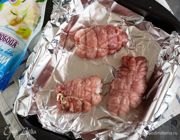 Положите на рабочую поверхность отбивные, посыпьте листочками свежего тимьяна (молодого), затем выложите на нее слой начинки (оставьте 3 ст. л.), не доходя до краев на 1 см. Сверните края (как у конвертика) и затем заверните в рулет и плотно обвяжите кулинарным шпагатом. Переложите рулетики в форму для запекания и поставьте в духовку.