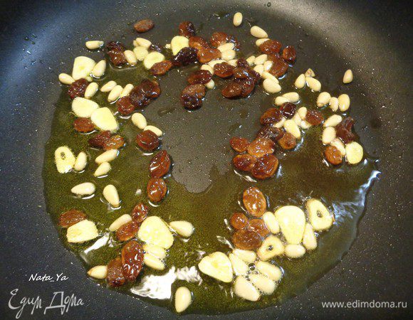 Отварите тальятелле до состояния аль денте. Часть воды, в которой варились тальятелле? сохраните. Чеснок очистите, нарежьте пластинками и спассеруйте на оливковом масле до состояния, когда он начнет менять цвет. Добавьте изюм и кедровые орешки.