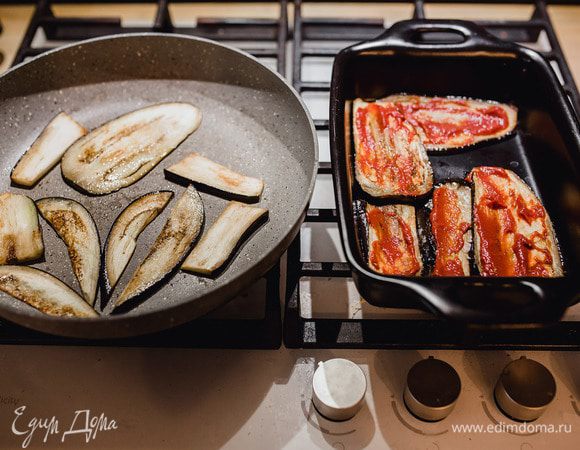 Баклажаны обсушить бумажными полотенцами. На разогретой с маслом сковороде обжарить с двух сторон их до золотистой корочки. Обжаренные слайсы выкладываем в форму для запекания и смазываем соусом из томатной пасты, базилика, соли и перца. Дальше выкладываем сырный слой (пармезан и моцарелла).