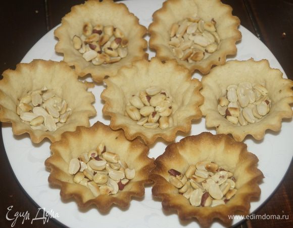 Теперь нужно собрать пирожное. На дно выложить арахис.
