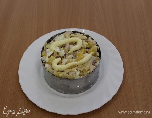 Выложить салат в кольцо, слегка смазать майонезом и присыпать грецкими орехами.