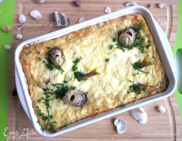 Поставить в духовку на 15 минут. Затем температуру духовки увеличить до 220°С, запекать еще 15 — 20 минут до румяной корочки. Вынуть из духовки, дать немного остыть, декорировать хвостиками консервированной  копченой корюшки в масле (килькой), головами воблы, мелко нарезанным шнитт-луком.


