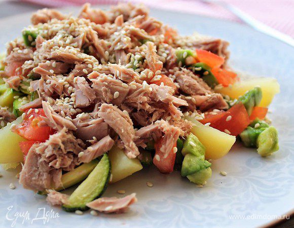 При подаче выкладываем на порционную тарелку дольки картофеля, сверху цукини, массу из томатов и авокадо. На подушку из овощей выкладываем тунец, поливаем кунжутным маслом и посыпаем золотистым кунжутом. Приятного аппетита!